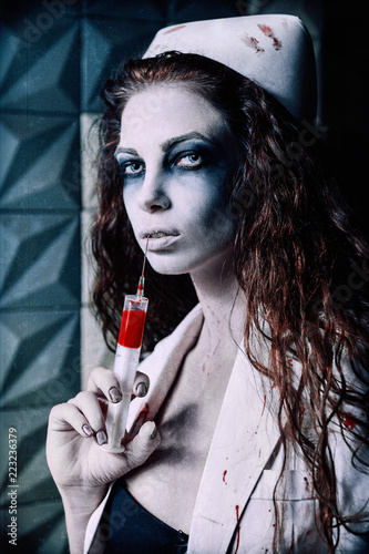 Fotografía Horror shot: scary evil nurse (doctor) with bloody syringe in hand