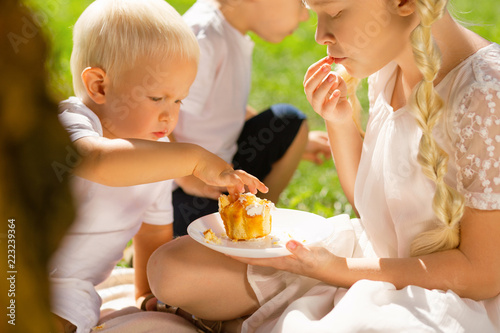 Favourite food. Little nice child being serious while eating a delicious cake photo