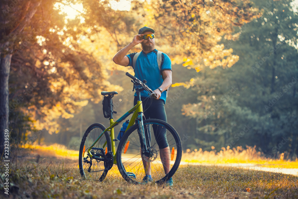 Obraz premium bearded man cyclist rides in the forest on a mountain bike.