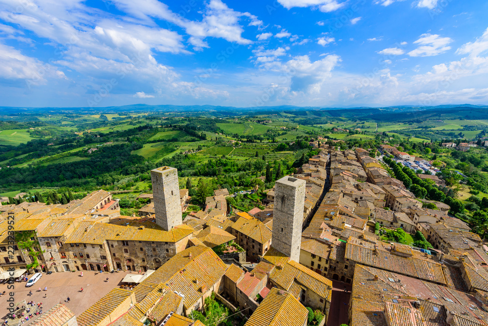Aerial view of the historic town of San Gimignano with beautiful landscape scenery on a sunny summer day in Tuscany, small walled medieval hill town with towers in the province of Siena, Italy