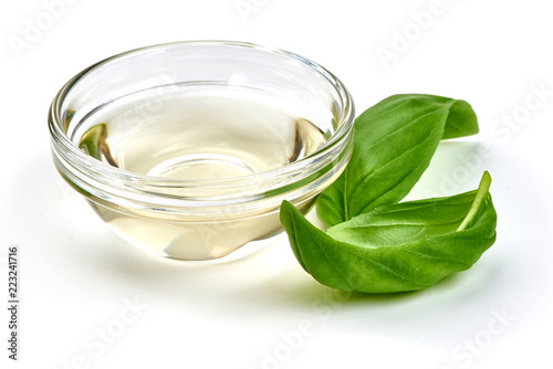 Vinegar in glass bowl with basil leaves, isolated on white background