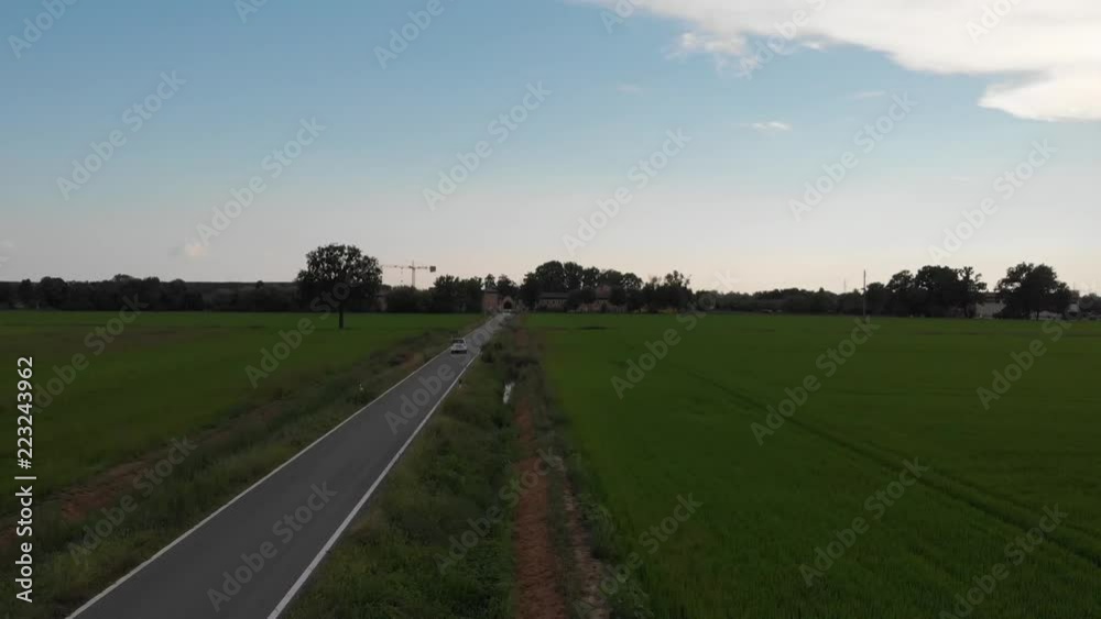 Country road in the field with a car Country road in the field with a car