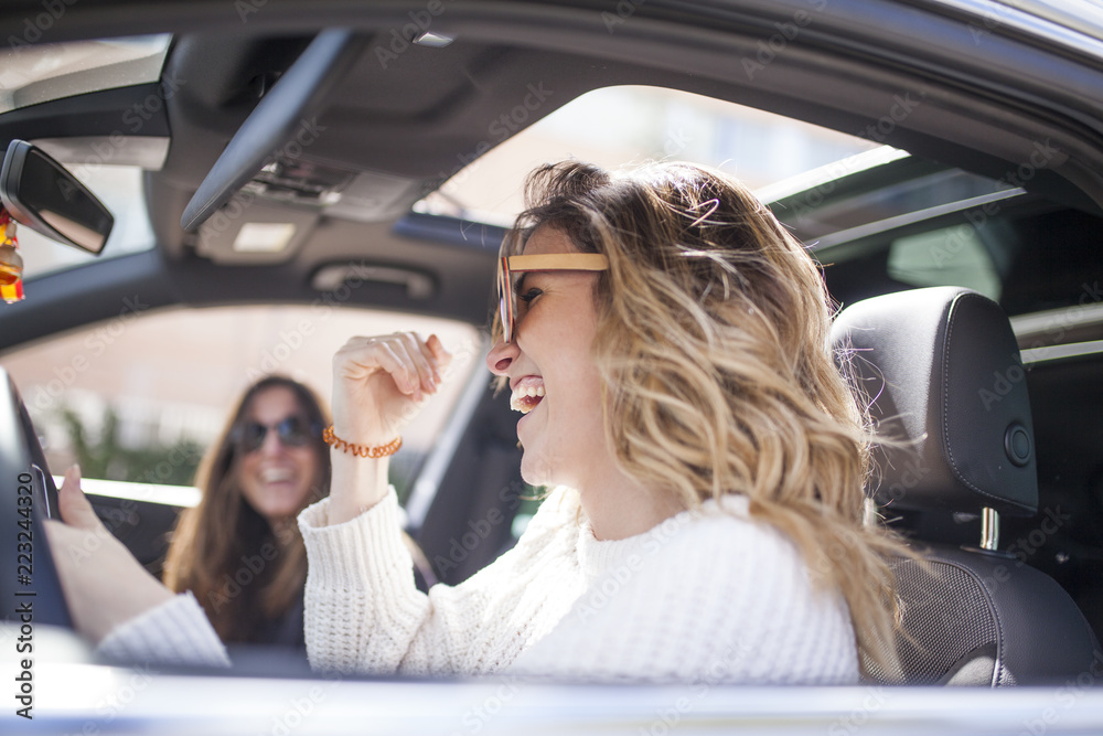 two women singing in the car