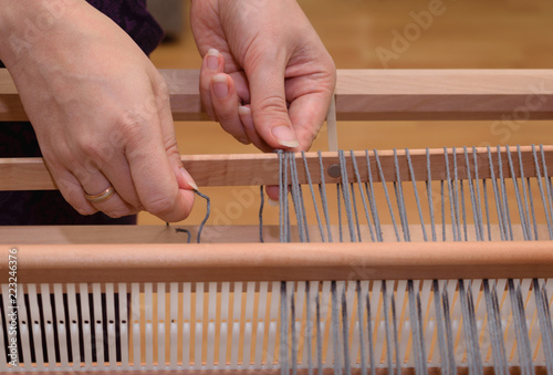 Close up of a hand warping a rigid heddle loom