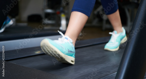 Female foot running on treadmill, close-up. Lower body at legs part of Fitness girl running on running machine or treadmill in fitness gym. Healthy and Exercise activity concept
