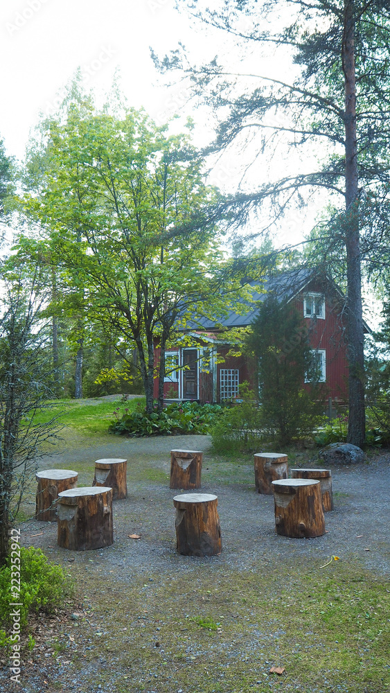 8 wooden stools outside in the forest next to a house 8 wooden stools outside in the forest next to a house