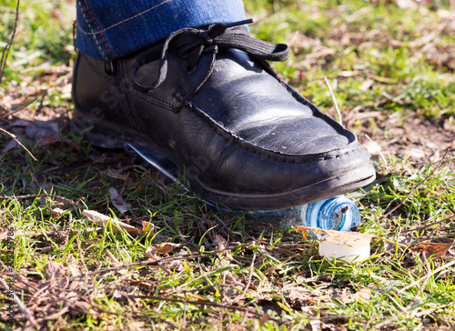 human trampled with the feet of plastic mineral water bottles and bottle caps on the grass in the park, the concept of environmental protection, fouling the environment