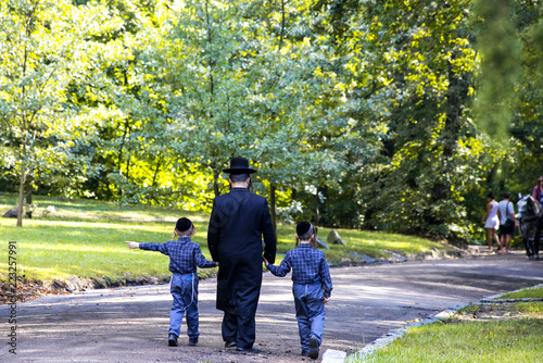 A family of Hasidic Jews, a man with children, walks through the Autumn Park in Uman, Ukraine, during the Jewish New Year,  Religious Orthodox Jew
