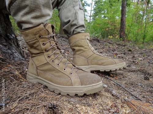 gray army boots on legs in the nature in the forest
