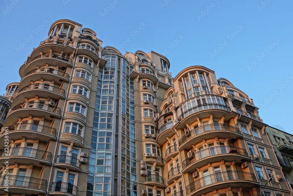 part of a large brown house with balconies and windows