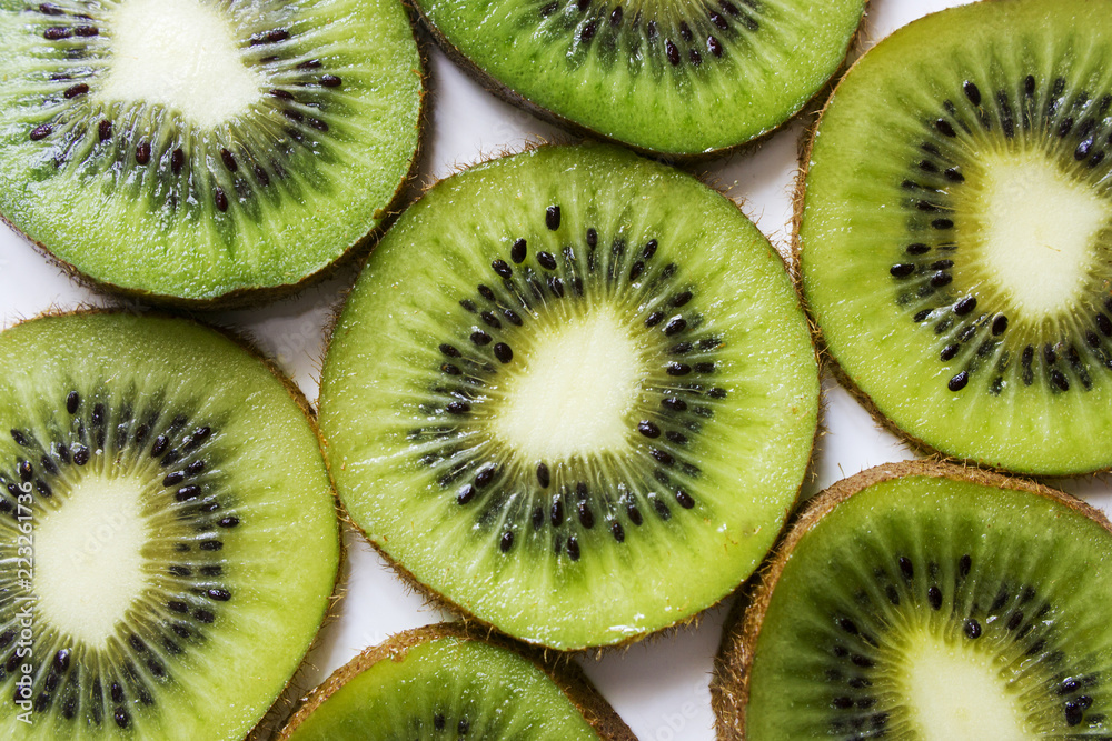 Kiwi fruit cut into pieces against a light background, close-up Kiwi fruit cut into pieces against a light background, close-up