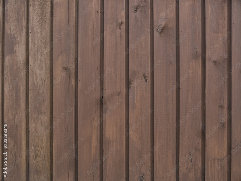 Vertical wooden boards brown on the wall as a background texture Vertical wooden boards brown on the wall as a background texture