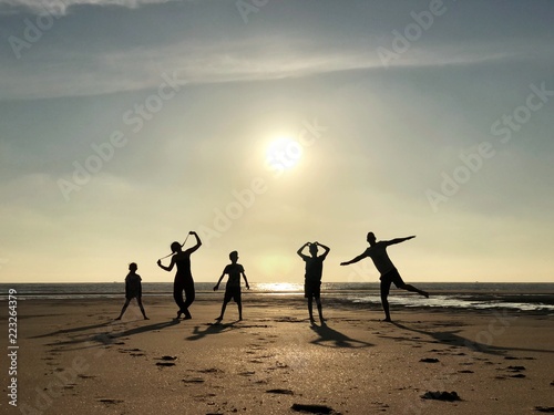 Silhouette of a family messing about on beach, Pointe Espagnole, La Tremblade, Charente-Maritime, France photo