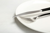 Plate with fork and knife on table, closeup. New setting