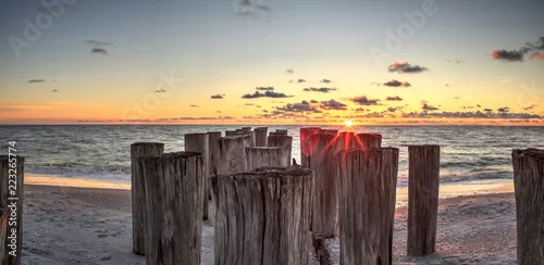 Fototapeta Obdrapane ruiny mola na Port Royal Beach o zachodzie słońca
