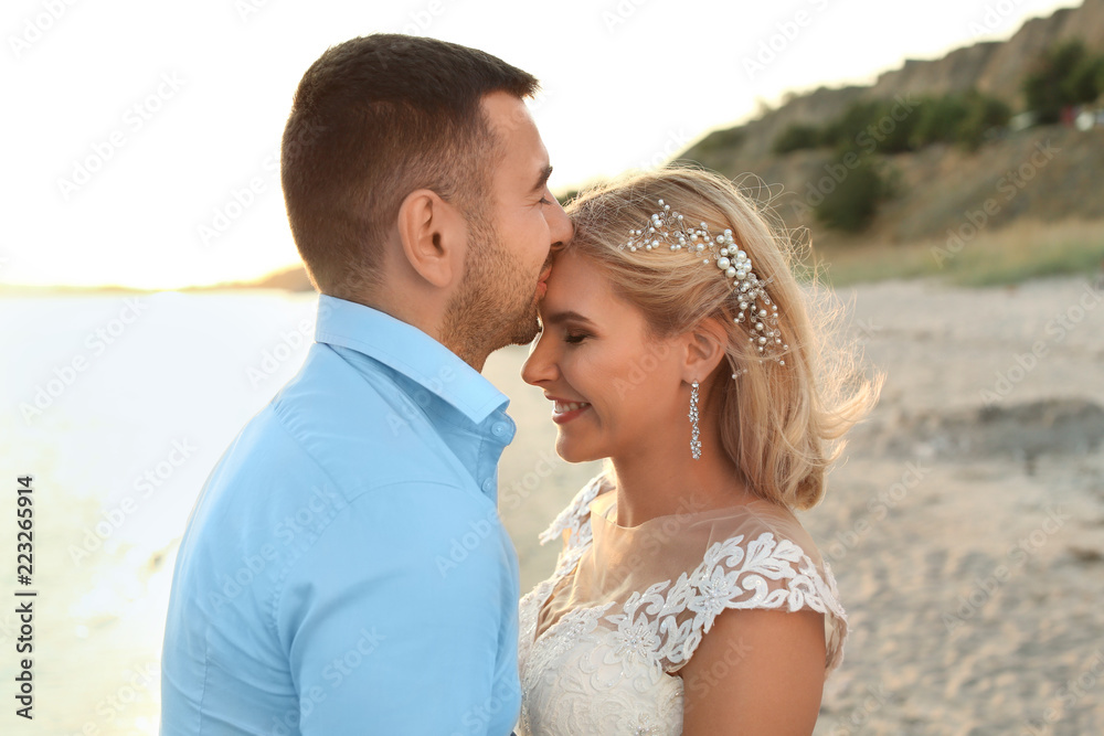 Wedding couple. Groom kissing bride on beach Wedding couple. Groom kissing bride on beach