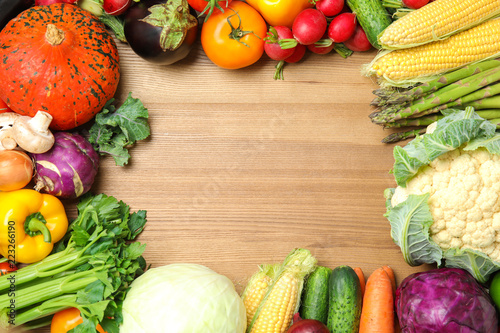 Flat lay composition with assortment of fresh vegetables on wooden background. Space for text
