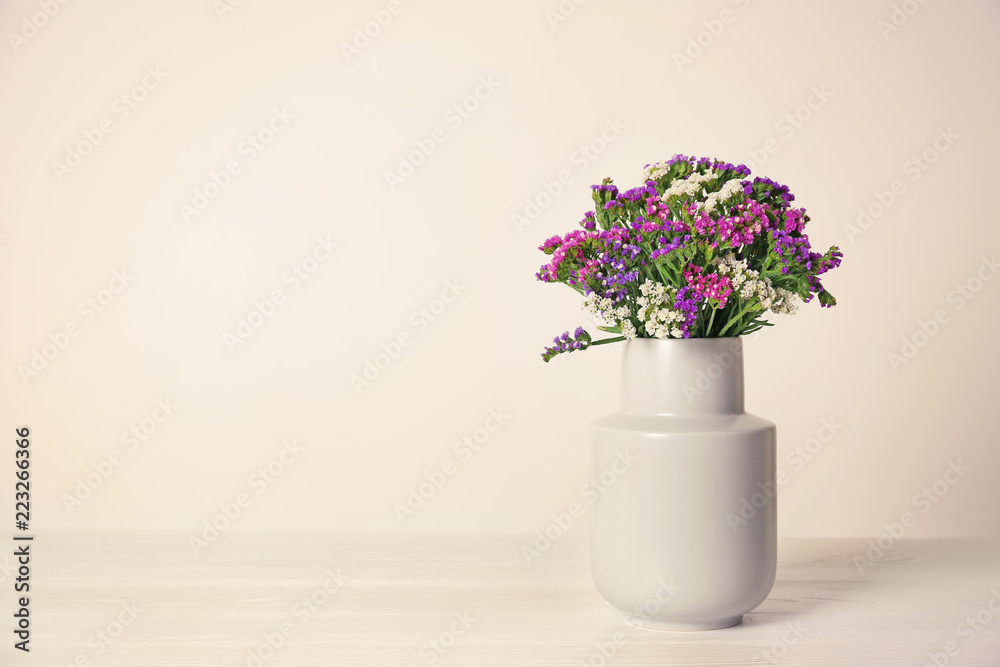 Beautiful flowers in vase and space for text on light background. Element of interior design Beautiful flowers in vase and space for text on light background. Element of interior design