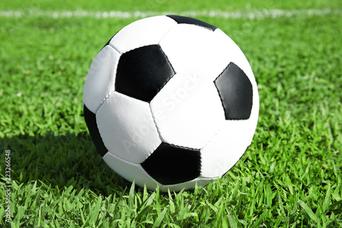 Soccer ball on fresh green football field grass