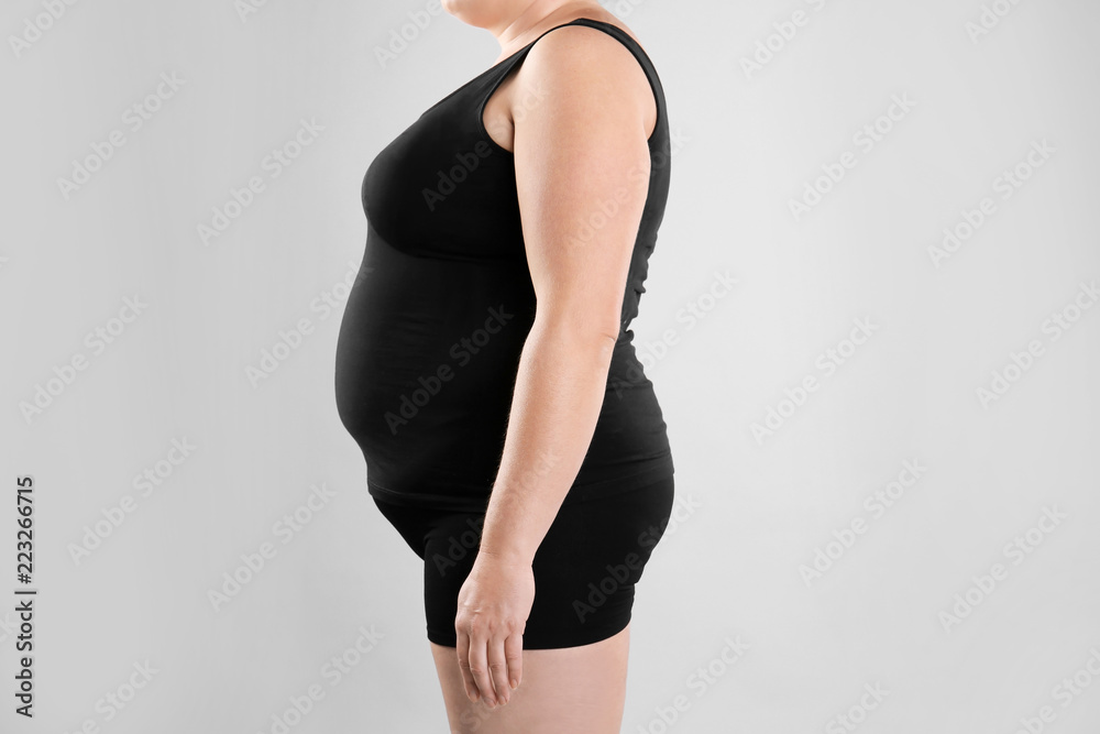 Fat woman on grey background, closeup. Weight loss Fat woman on grey background, closeup. Weight loss