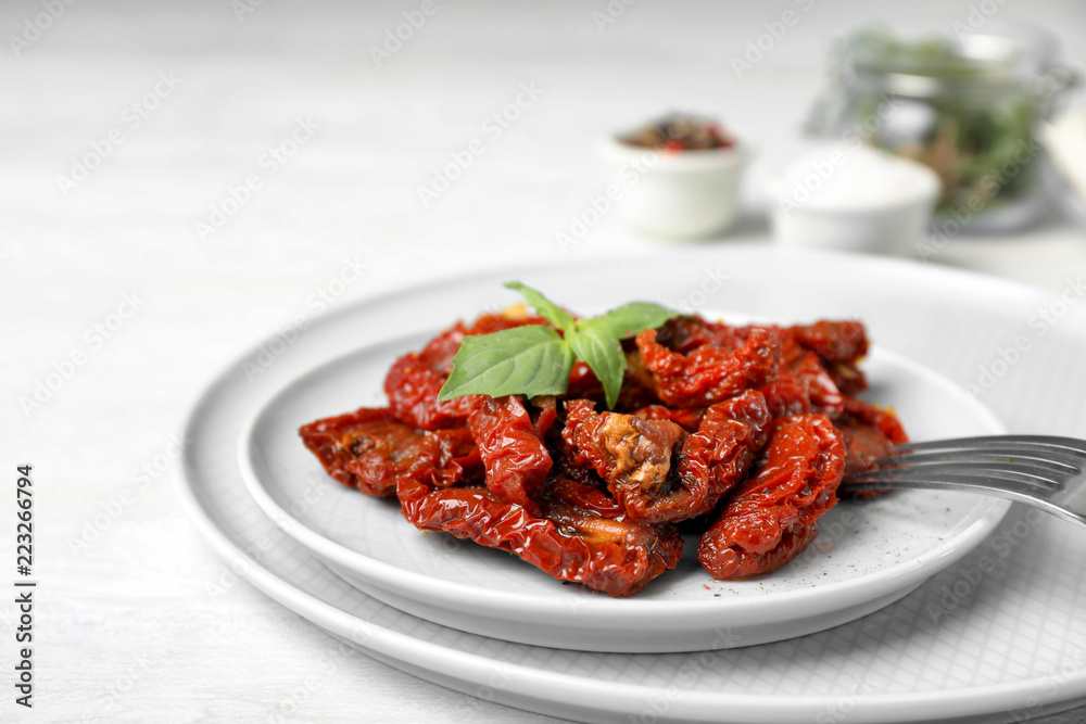 Plate with sun dried tomatoes on light table Plate with sun dried tomatoes on light table