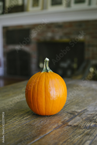 View of a sugar pumpkin on a farm table within a warm house with copy space