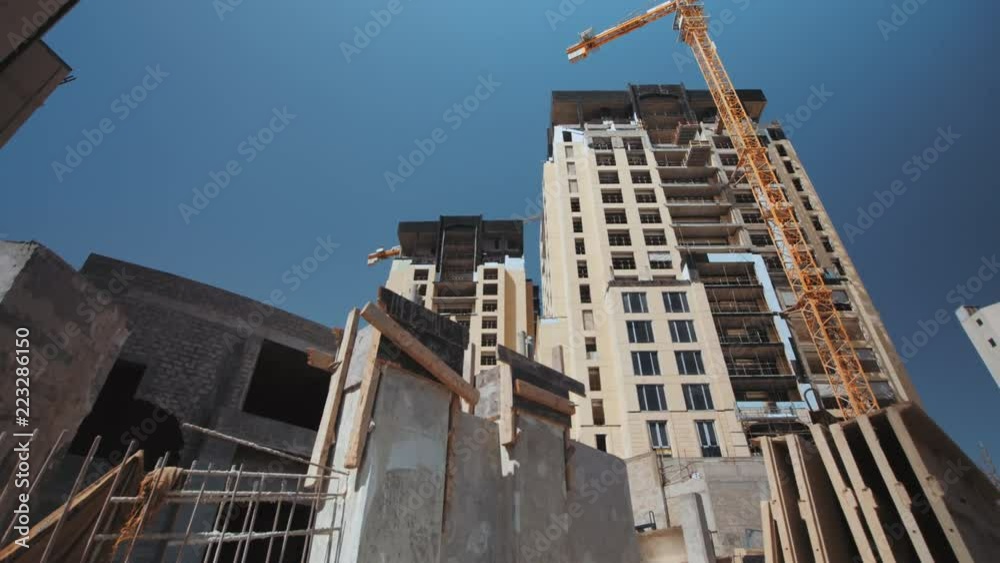Constructions, Compound 2 clips of a construction site, Wide shot side Dolly right, wide shot pan right, construction building with crane, sunny summer day, 4K footage Constructions, Compound 2 clips of a construction site, Wide shot side Dolly right, wide shot pan right, construction building with crane, sunny summer day, 4K footage