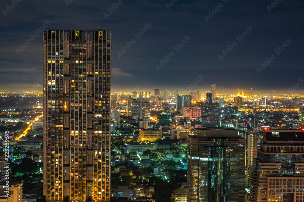 Aerial Bangkok Skyline Buildings around Silom Area with Iconic Condominium in the Cloudy day with light from the City.