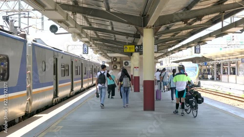 Travelers getting off of the public train and walking along the station platform in Hsinchu City, Taiwan.