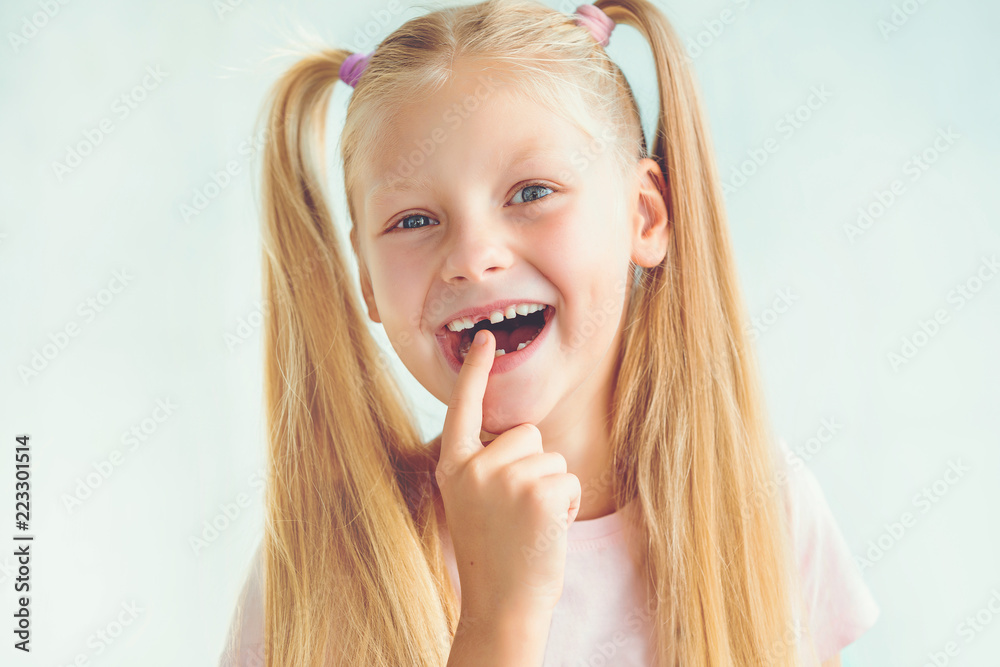 Portrait of a smiling little girl after dropping her front baby tooth Portrait of a smiling little girl after dropping her front baby tooth
