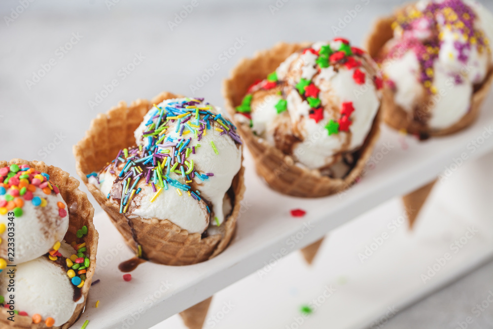 ice cream in cone with confectionery powder on stand over white background ice cream in cone with confectionery powder on stand over white background