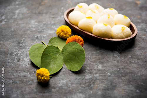 Happy Dussehra / Vijayadashami / Ayudh Puja greeting card using apta/Bauhinia racemosa/Bidi leaf and indian sweet Rasgulla for Navaratri photo