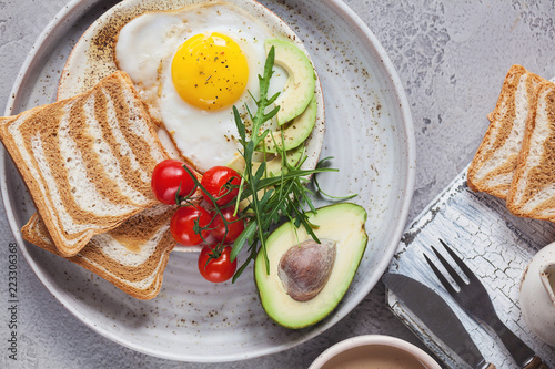 Obraz na plátne breakfast with fried egg with avocado, tomatoes and bread