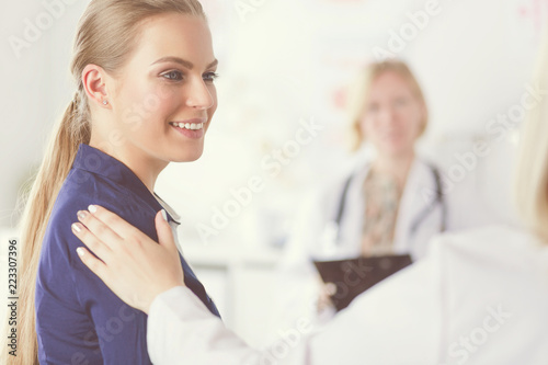 Doctor and patient discussing something while sitting at the table . Medicine and health care concept