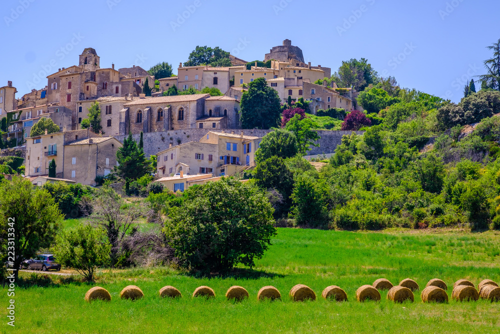 Vue panoramique sur le village de Simiane-la-Rotonde.  Provence, France. Les rouleaux de paille au premier plan.