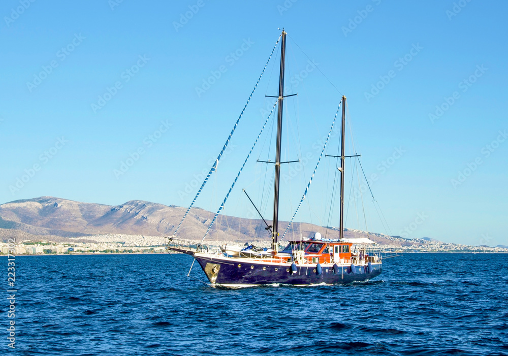 A nice beautiful wooden hull floating in blue waters of Saronic gulf. Piraeus, Greece.