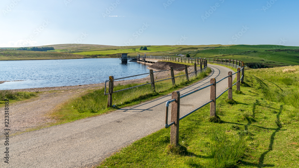 Rural road in Wales, leading over the dam at the Aled Isaf Reservoir, Conwy, Wales, UK