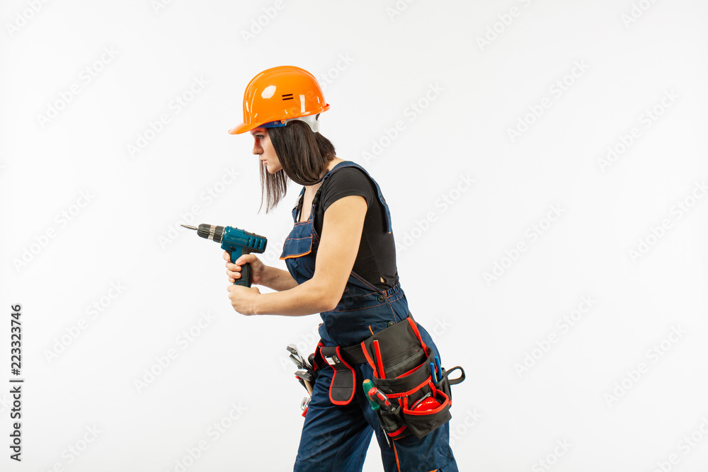 Young woman with toolbelt using driil and some power tools for her work at home. Girl working at flat remodeling. Building, repair and renovation. Young woman with toolbelt using driil and some power tools for her work at home. Girl working at flat remodeling. Building, repair and renovation.