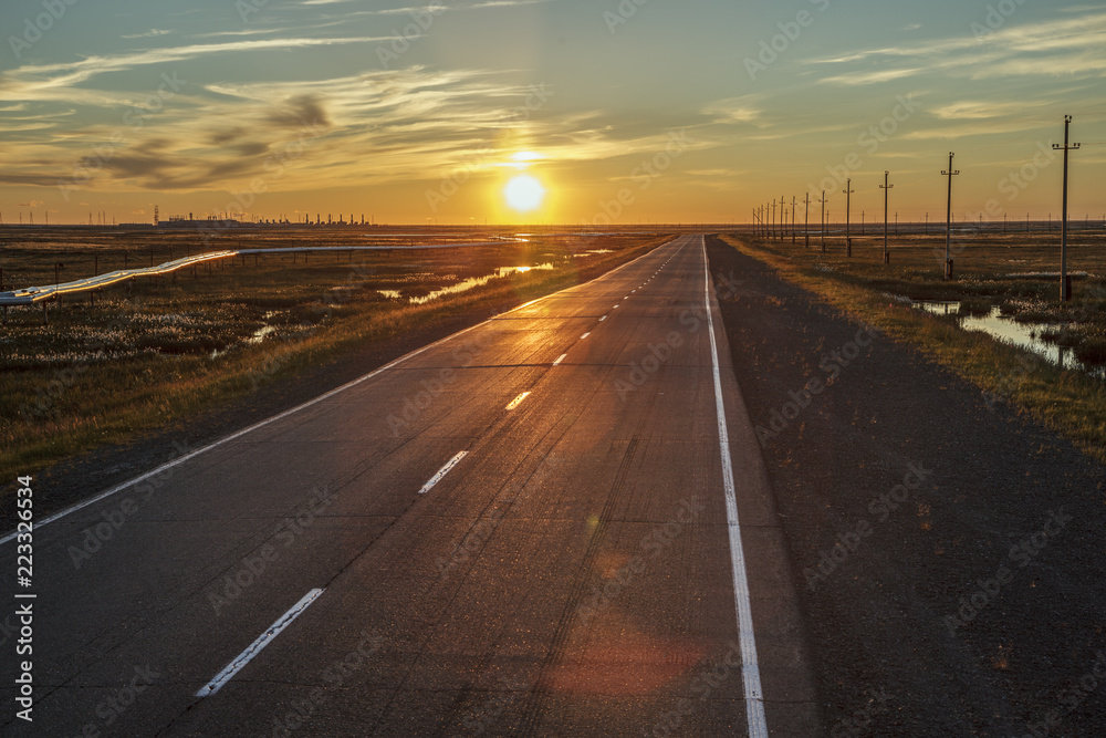 Beautiful sunset on the background of an asphalt road