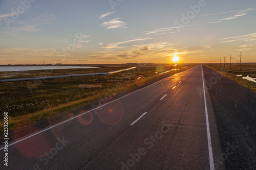 Beautiful sunset on the background of an asphalt road © evgenii