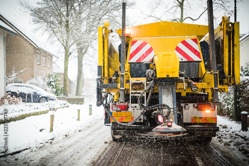 Winter road maintenance truck spreading salt photo