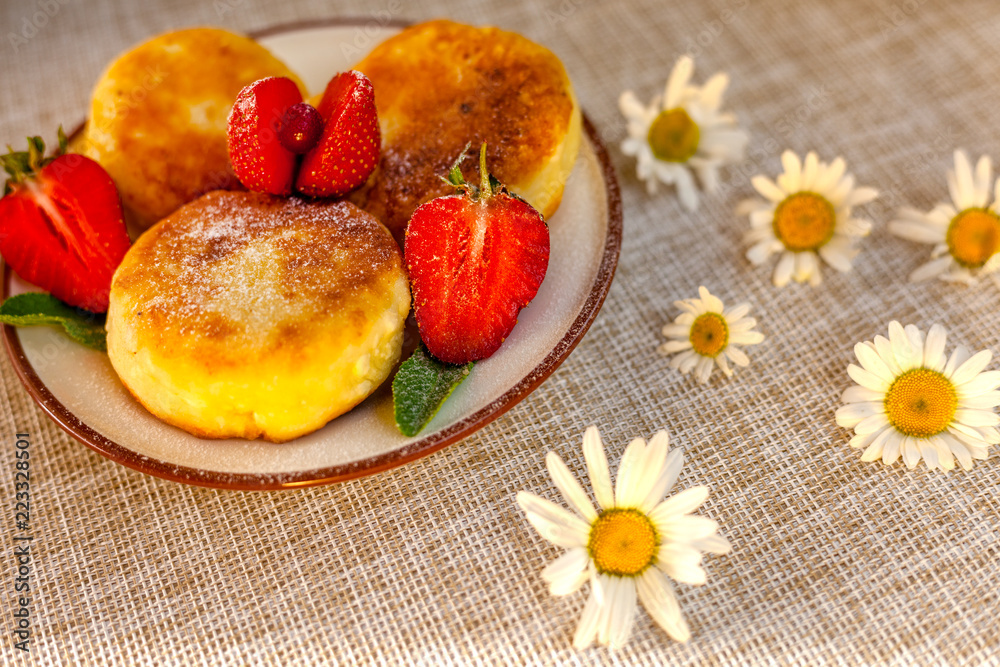 A large plate with curd cheese for breakfast, Cottage cheese pancakes, curd fritters with fresh berries strawberries with daisy flowers A large plate with curd cheese for breakfast, Cottage cheese pancakes, curd fritters with fresh berries strawberries with daisy flowers