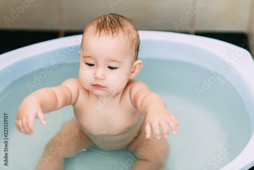 Valokuvatapetti Girl having fun bathing in the bathroom in the basin