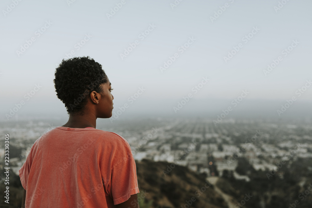 Woman looking out over the city - obrazy, fototapety, plakaty 