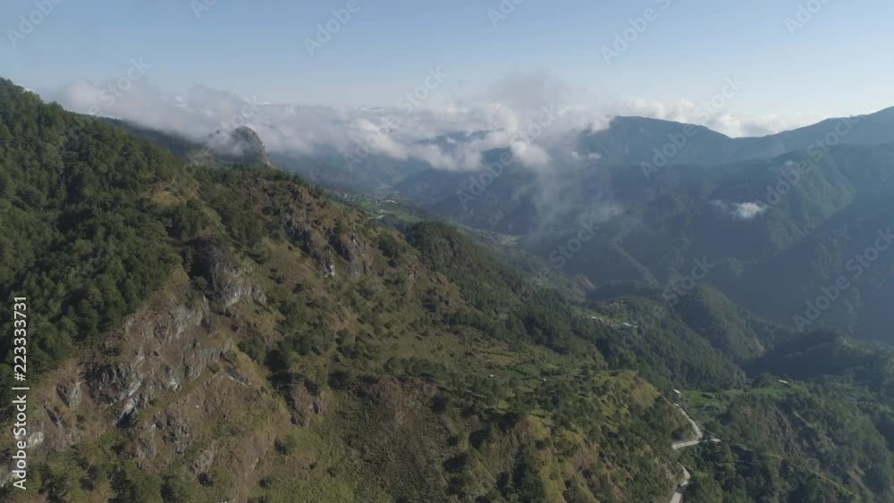 Aerial view of mountains covered forest, trees in clouds. Cordillera region. Luzon, Philippines. Slopes of mountains with evergreen vegetation. Mountainous tropical landscape. Aerial view of mountains covered forest, trees in clouds. Cordillera region. Luzon, Philippines. Slopes of mountains with evergreen vegetation. Mountainous tropical landscape.