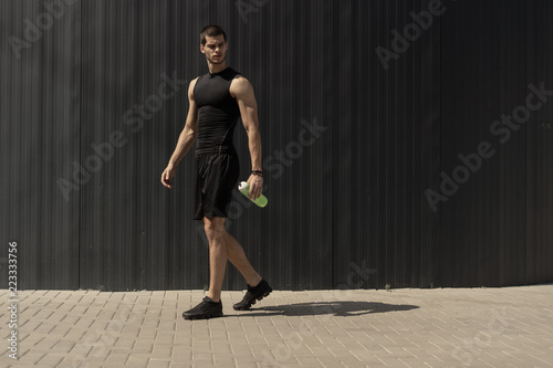 Athletic modern young man posing on a gray metallic wall copy sp