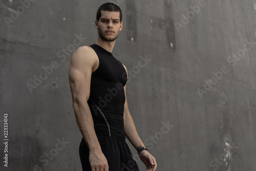 Sport model man posing gray wall background