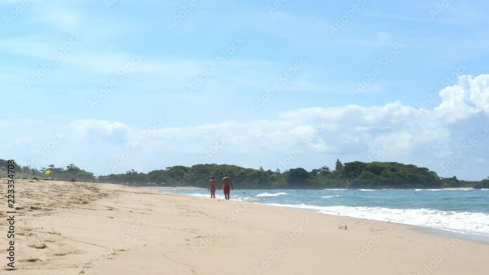 Young couple walking in tropical beach afternoon Young couple walking in tropical beach afternoon