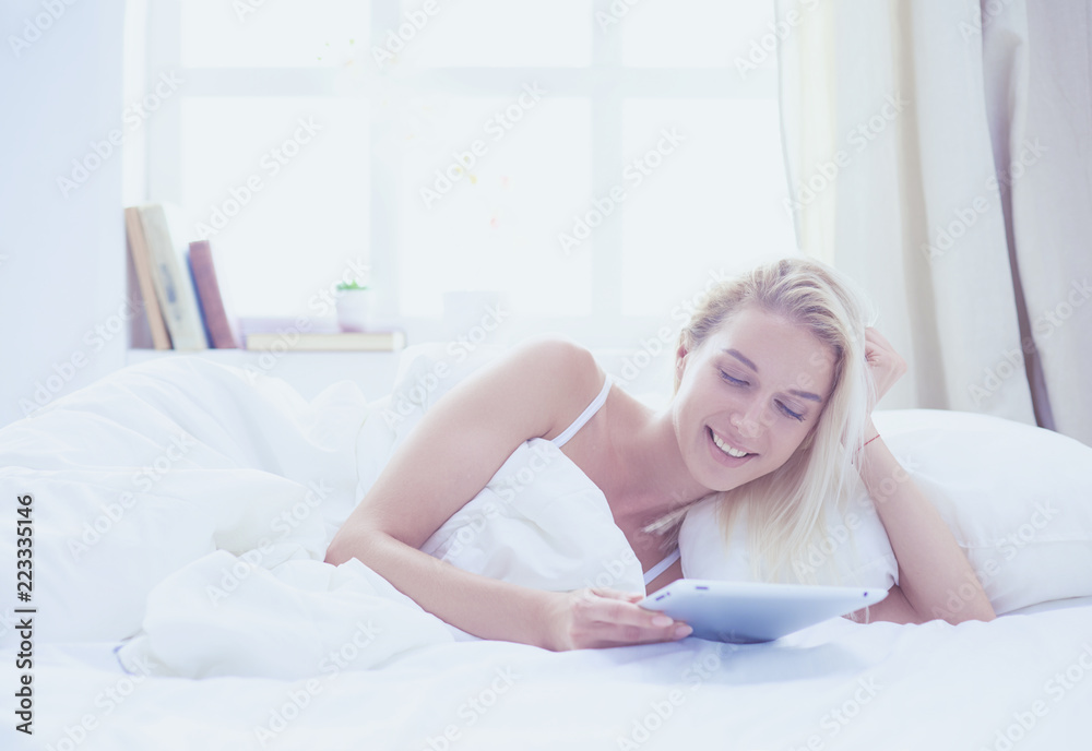 Girl holding digital tablet with blank screen and smiling at camera in bedroom Girl holding digital tablet with blank screen and smiling at camera in bedroom
