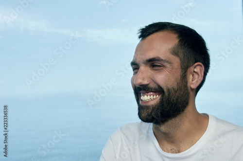 Handsome man smiling on the deck of a ship during holidays.